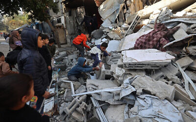 Palestinians look for their belongings amid the debris of a collapsed house previously damaged at the Maghazi refugee camp in the central of Gaza Strip on January 5, 2026. (Eyad Baba/AFP)