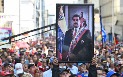A supporter of ousted Venezuelan President Nicolas Maduro carries his portrait during a rally outside the National Assembly in Caracas on January 5, 2026. (Juan BARRETO / AFP)