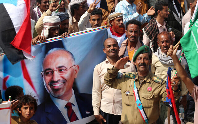 Yemeni members of the Sabahiha tribes of Lahj, who support the UAE-backed Southern Transitional Council (STC), hold an image of the STC leader Aidarous Al-Zubaidi as they wave the old South Yemen flag during a rally on December 14, 2025. (Saleh Al-OBEIDI / AFP)