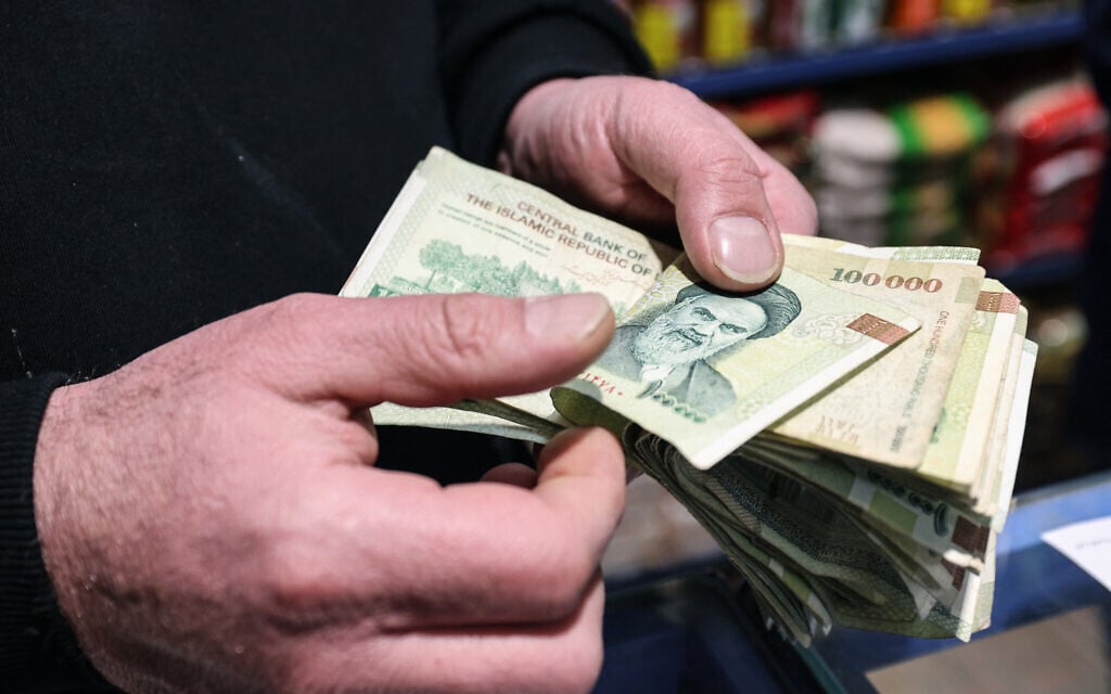 A shop owner counts Iranian banknotes at a store in the capital Tehran on January 7, 2026. (Atta Kenare/AFP) A shop owner counts Iranian banknotes at a store in the capital Tehran on January 7, 2026. (Atta Kenare/AFP)