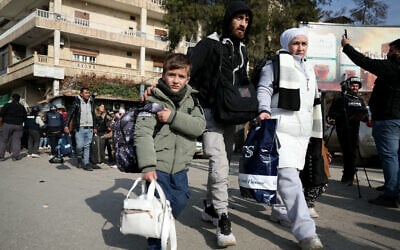 Residents flee from the predominantly Kurdish neighborhoods of Sheikh Maqsud and Achrafieh in the city of Aleppo, northern Syria, on January 8, 2026, amid intense clashes between government forces and the Kurdish Syrian Democratic Forces (SDF). (OMAR HAJ KADOUR / AFP)