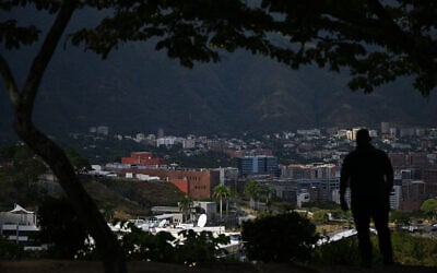 A man is seen with the city of Caracas in the background on January 9, 2026 (Federico PARRA / AFP)