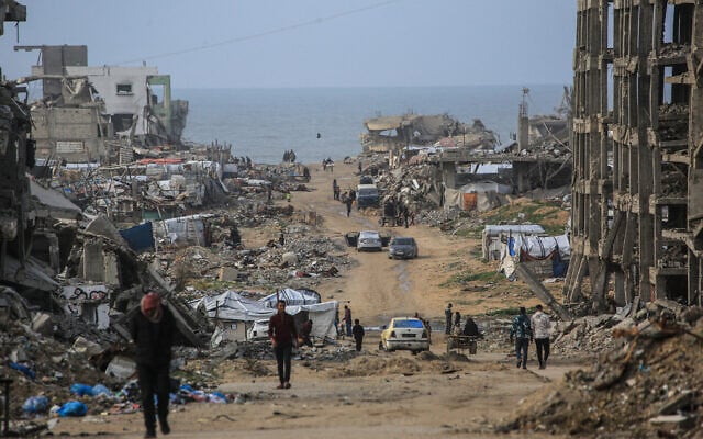 Palestinians walk along a road among destroyed buildings in Jabalia, in the northern Gaza Strip, on January 10, 2026. (Bashar Taleb / AFP) Palestinians walk along a road among destroyed buildings in Jabalia, in the northern Gaza Strip, on January 10, 2026. (Bashar Taleb / AFP)