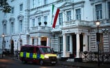 A police van waits outside the Iranian Embassy, flying the flag of the Islamic Republic of Iran, central London, January 12, 2026. (HENRY NICHOLLS / AFP)