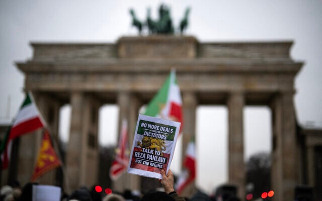 A demonstrator displays a placard calling for dialogue with Reza Pahlavi at an anti-Iranian regime protest in front of the Brandenburg Gate in Berlin, Germany, on January 12, 2026. (John MACDOUGALL / AFP) A demonstrator displays a placard calling for dialogue with Reza Pahlavi at an anti-Iranian regime protest in front of the Brandenburg Gate in Berlin, Germany, on January 12, 2026. (John MACDOUGALL / AFP)