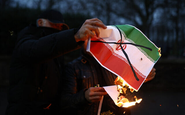 Anti-Iranian regime protesters burn an image of the Iranian flag, during a gathering outside the Iranian Embassy, central London, on January 12, 2026. (Henry NICHOLLS / AFP) Anti-Iranian regime protesters burn an image of the Iranian flag, during a gathering outside the Iranian Embassy, central London, on January 12, 2026. (Henry NICHOLLS / AFP)