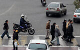 Illustrative: Iranians cross a street in the capital Tehran on January 15, 2026. (ATTA KENARE / AFP)