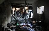 Palestinian men maneuver past debris and broken furniture, after an Israeli strike on the family home of Hamas military commander Muhammad al-Hawli, west of Deir al-Balah, in the central Gaza Strip on January 16, 2026.  (Basahr Taleb/AFP)