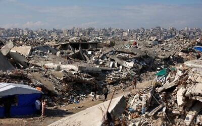 Displaced Palestinians walk amongst the rubble in the Jabalia refugee camp, in the northern Gaza Strip on January 17, 2026. (Omar AL-QATTAA / AFP)