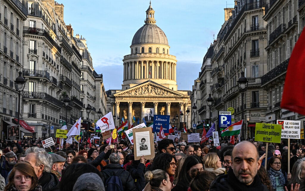 Protesters hold banners and Iranian flags during a rally in support of the Iranian people in front of the Pantheon in Paris on January 17, 2026. (JULIEN DE ROSA / AFP)