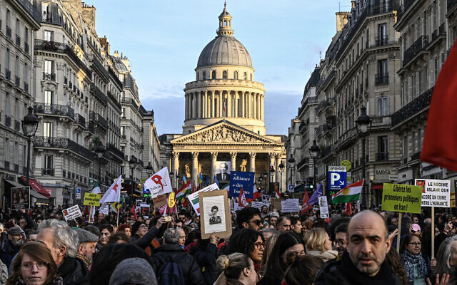 Protesters hold banners and Iranian flags during a rally in support of the Iranian people in front of the Pantheon in Paris on January 17, 2026. (JULIEN DE ROSA / AFP)