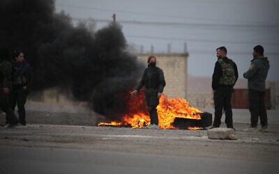 Kurdish fighters stand near burning tires at the entrance to the city of Tabqa in the northern Syrian Raqa province, on January 17, 2026. (Delil SOULEIMAN / AFP) Kurdish fighters stand near burning tires at the entrance to the city of Tabqa in the northern Syrian Raqa province, on January 17, 2026. (Delil SOULEIMAN / AFP)