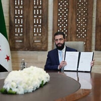 Syria's President Ahmed al-Sharaa signs an agreement with the chief of the Kurdish-led Syrian Democratic Forces at the Presidential Palace in Damascus on January 18, 2026. (Rami al SAYED / AFP)