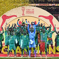 Senegal's forward #10 Sadio Mane holds up the trophy as he celebrates with his teammates after winning the Africa Cup of Nations (CAN) final soccer match against Morocco at the Prince Moulay Abdellah Stadium, in Rabat, Morocco, on January 18, 2026. (SEBASTIEN BOZON / AFP)
