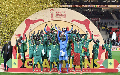 Senegal's forward #10 Sadio Mane holds up the trophy as he celebrates with his teammates after winning the Africa Cup of Nations (CAN) final soccer match against Morocco at the Prince Moulay Abdellah Stadium, in Rabat, Morocco, on January 18, 2026. (SEBASTIEN BOZON / AFP)