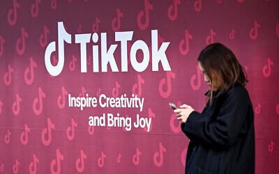 A woman uses her phone in front of TikTok's booth during the World Economic Forum (WEF) annual meeting in Davos on January 19, 2026. (Ina Fassbender / AFP) A woman uses her phone in front of TikTok's booth during the World Economic Forum (WEF) annual meeting in Davos on January 19, 2026. (Ina Fassbender / AFP)