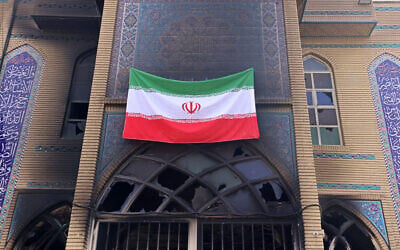 This photograph taken during a tour for foreign media shows an Iranian national flag installed on the Beheshti Mosque that was damaged during anti-regime protests that were brutally repressed by the Islamic Republic, in Tehran, Iran, January 21, 2026. (ATTA KENARE / AFP)