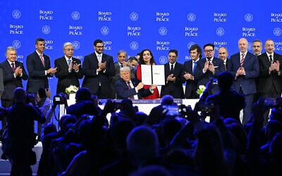 Paraguay's President Santiago Pena (second from left), Pakistan's Prime Minister Shehbaz Sharif (fifth from left), Kosovo's President Vjosa Osmani (center right), Argentina's President Javier Milei (sixth from right), Armenia's Prime Minister Nikol Pashinyan (fourth from right), Bulgaria's former Prime Minister Rosen Zhelyazkov (third from right), Turkey's Foreign Minister Hakan Fidan (second from right) and Azerbaijan's President Ilham Aliyev pose with US President Donald Trump (center) holding a signed founding charter at the 'Board of Peace' meeting during the World Economic Forum (WEF) annual meeting in Davos, Switzerland, on January 22, 2026. (Fabrice Coffrini / AFP)