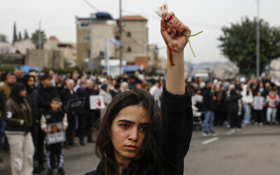 A woman raises flowers, with red marks visible on her hand, as Arab protesters gather in Sakhnin in northern Israel, on January 22, 2026, to protest what they say is police inaction on curbing soaring violent crime in the community. (Jalaa MAREY / AFP) A woman raises flowers, with red marks visible on her hand, as Arab protesters gather in Sakhnin in northern Israel, on January 22, 2026, to protest what they say is police inaction on curbing soaring violent crime in the community. (Jalaa MAREY / AFP)