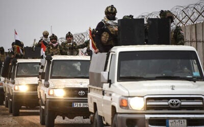 Members of the Iraqi Popular Mobilization Forces drive along the border with Syria in the Tarfawi area of northwestern Iraq on January 22, 2026. (Zaid AL-OBEIDI / AFP)