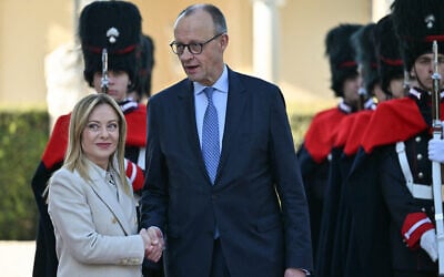Italian Prime Minister Giorgia Meloni and German Chancellor Friedrich Merz shake hands after reviewing an honor guard before an intergovernmental summit between Italy and Germany, at Villa Doria Pamphilj in Rome on January 23, 2026. (Andreas Solaro/AFP)