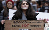 A demonstrator wears a sticker over her mouth with the words "no execution" during a silent march denouncing the Iranian government's deadly crackdown on anti-government protesters in the Islamic Republic, in Paris on January 31, 2026. (Sébastien DUPUY / AFP)