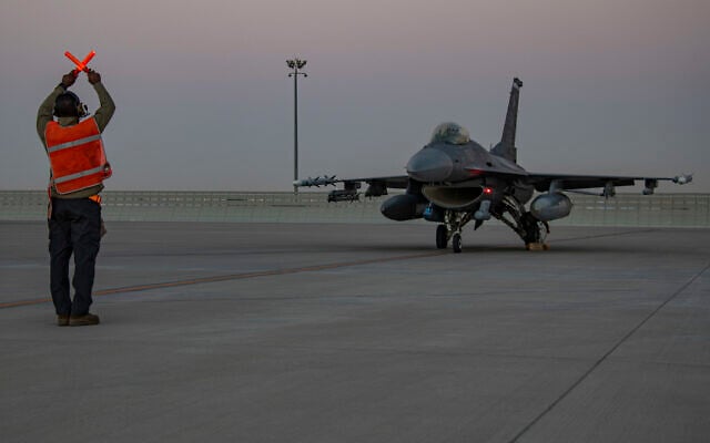 In this handout photo from the U.S. Air Force, an airman guides an F-16 Fighting Falcon during training at Al-Udeid Air Base, Qatar, January 24, 2022. (US Air Force/Capt. Mahalia Frost, via AP)