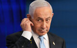 Prime Minister Benjamin Netanyahu adjusts the headphones during a joint press conference with German Chancellor Friedrich Merz in Jerusalem, December 7, 2025. (AP/Ariel Schalit, Pool, File)