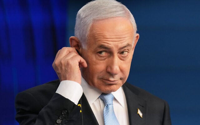 Prime Minister Benjamin Netanyahu adjusts the headphones during a joint press conference with German Chancellor Friedrich Merz in Jerusalem, December 7, 2025. (AP/Ariel Schalit, Pool, File) Prime Minister Benjamin Netanyahu adjusts the headphones during a joint press conference with German Chancellor Friedrich Merz in Jerusalem, December 7, 2025. (AP/Ariel Schalit, Pool, File)