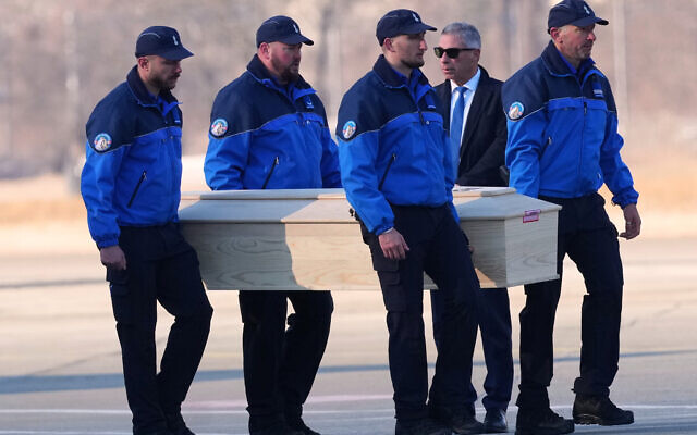 Police officers carry a coffin with the body of one of six Italians at the Military Airport in Sion, Swiss Alps, Switzerland, Jan. 5, 2026, following a devastating fire in a bar in Crans-Montana during the New Year's celebrations. (AP Photo/Antonio Calanni)