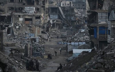 Illustrative: Palestinians walk amid buildings destroyed by Israeli air and ground operations in Gaza City, January 6, 2026. (AP/Jehad Alshrafi)