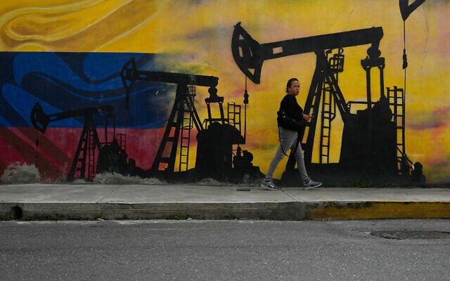 A local walks past a mural featuring oil pumps and wells in Caracas, Venezuela, January 6, 2026. (AP/Matias Delacroix)
