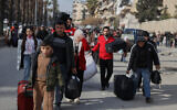 Residents flee the Sheikh Maqsoud and Achrafieh neighborhoods after clashes broke out between Syrian government forces and Kurdish fighters in a contested area of the northern city of Aleppo, Syria, January 7, 2026. (AP/Omar Albam)