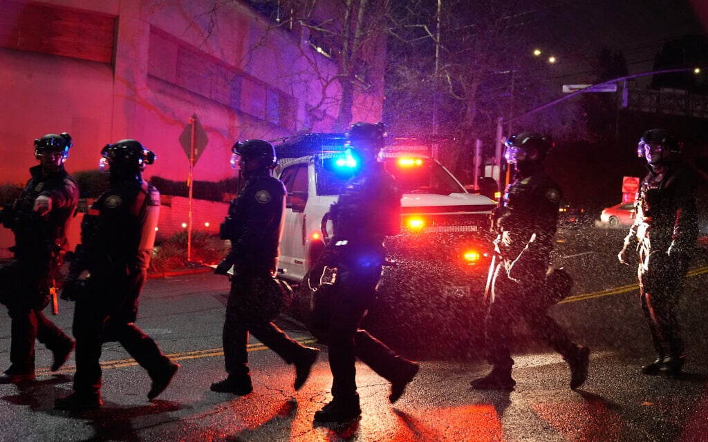 Portland police officers walk outside the US Immigration and Customs Enforcement facility on January 8, 2026, in Portland, Oregon. (AP/Jenny Kane)