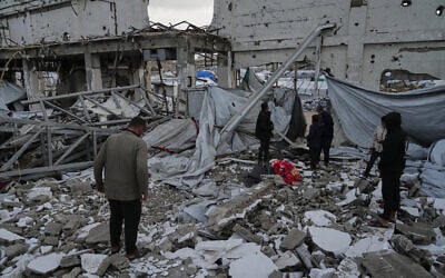 People inspect the site where at least three Palestinians died following the collapse of walls onto tents sheltering displaced people in Gaza City amid rainfall and strong winds, Tuesday, Jan. 13, 2026. (AP Photo/Jehad Alshrafi)