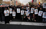 People hold posters of the Iranian Supreme Leader Ayatollah Ali Khamenei during a funeral ceremony for a group of security forces, who were killed during anti-government protests, in Tehran, Iran, January 14, 2026. (Vahid Salemi/AP)