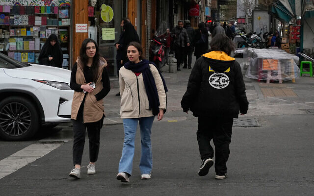 People cross an intersection in downtown Tehran, Iran, Thursday, Jan. 15, 2026. (AP Photo/Vahid Salemi)