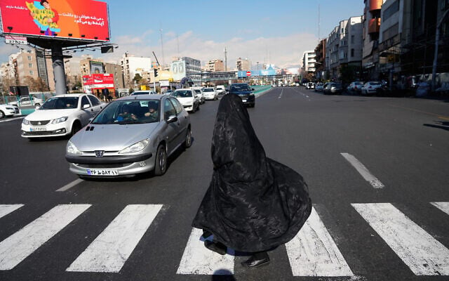 A woman crosses an intersection in downtown Tehran, Iran, January 16, 2026. (AP Photo/Vahid Salemi)