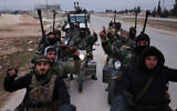 Syrian government soldiers carry machine guns as they ride motorcycles on a road leading to the town of Deir Hafer, Syria, January 17, 2026. (AP Photo/Ghaith Alsayed)