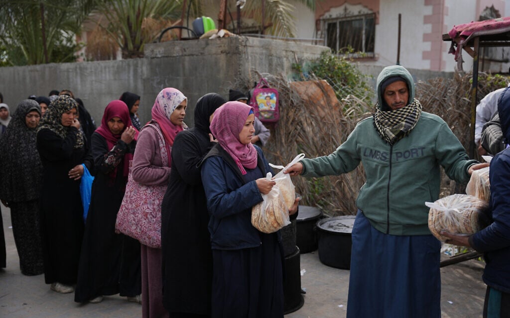 Palestinian women line up to receive donated food at a community kitchen in Deir al-Balah, central Gaza Strip, January 21, 2026. (AP Photo/Abdel Kareem Hana)
