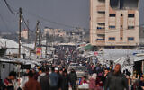 Palestinians walk along a street market in Khan Younis, southern Gaza Strip, January 23, 2026. (AP Photo/Abdel Kareem Hana)