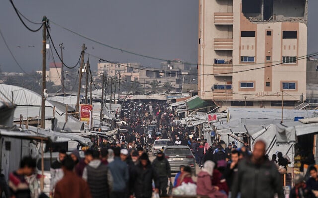 Palestinians walk along a street market in Khan Younis, southern Gaza Strip, January 23, 2026. (AP Photo/Abdel Kareem Hana)
