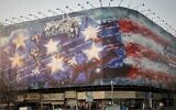 A billboard depicting a damaged US aircraft carrier with disabled fighter jets on its deck and a sign reading in Farsi and English, "If you sow the wind, you'll reap the whirlwind," at Enghelab Square Square in Tehran, Iran, January 25, 2026. (AP Photo/Vahid Salemi)
