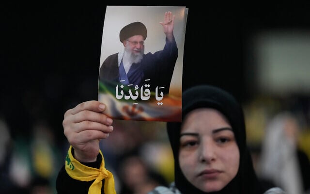 A Hezbollah supporter holds up a portrait of the Iranian Supreme Leader Ayatollah Ali Khamenei, that reads in Arabic: "Oh leader" during a rally to show solidarity with Iran, in the southern suburb of Beirut, Lebanon, Monday, Jan. 26, 2026. (AP Photo/Hussein Malla)
