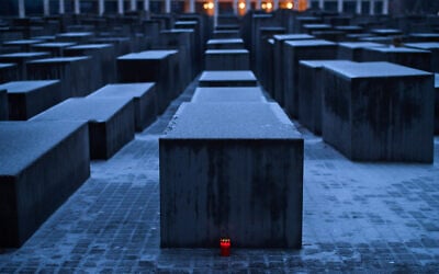 A candle is placed at the Holocaust memorial, covered with ice, on the eve of the International Holocaust Memorial Day in Berlin, Germany, January 26, 2026. (AP Photo/Markus Schreiber)