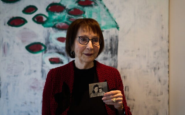 Holocaust survivor Ilana Shalem-Kantorowics, born in the Nazi Bergen-Belsen concentration camp, holds a photo of her with her mother Lola taken in the Bergen-Belsen refugee camp in 1946, in Tel Aviv, Israel, January 26, 2026. (Ariel Schalit/AP)