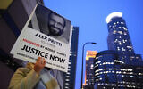 A person holds a sign of Alex Pretti during a protest outside the office of US Senator Amy Klobuchar on January 26, 2026, in Minneapolis. (AP Photo/Adam Gray)