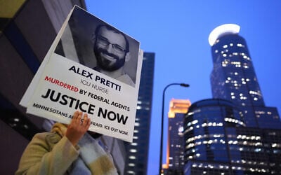 A person holds a sign of Alex Pretti during a protest outside the office of US Senator Amy Klobuchar on January 26, 2026, in Minneapolis. (AP Photo/Adam Gray)