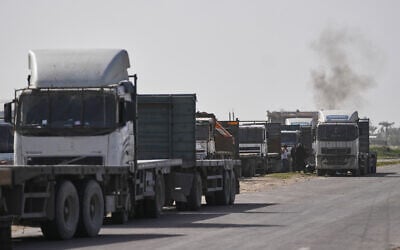 Palestinian commercial trucks are seen parked in an area in Deir al-Balah near the Kissufim crossing in the Gaza Strip as they wait for permission to receive a cargo of goods for sale in the enclave, January 27, 2026. (AP/Abdel Kareem Hana)
