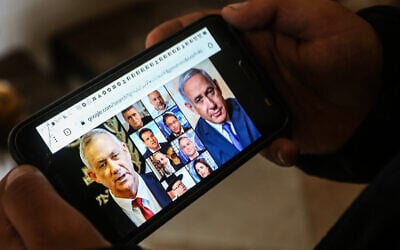 Illustrative: A phone shows the faces of Israeli political figures on March 2, 2020. (Abed Rahim Khatib/ Flash90)